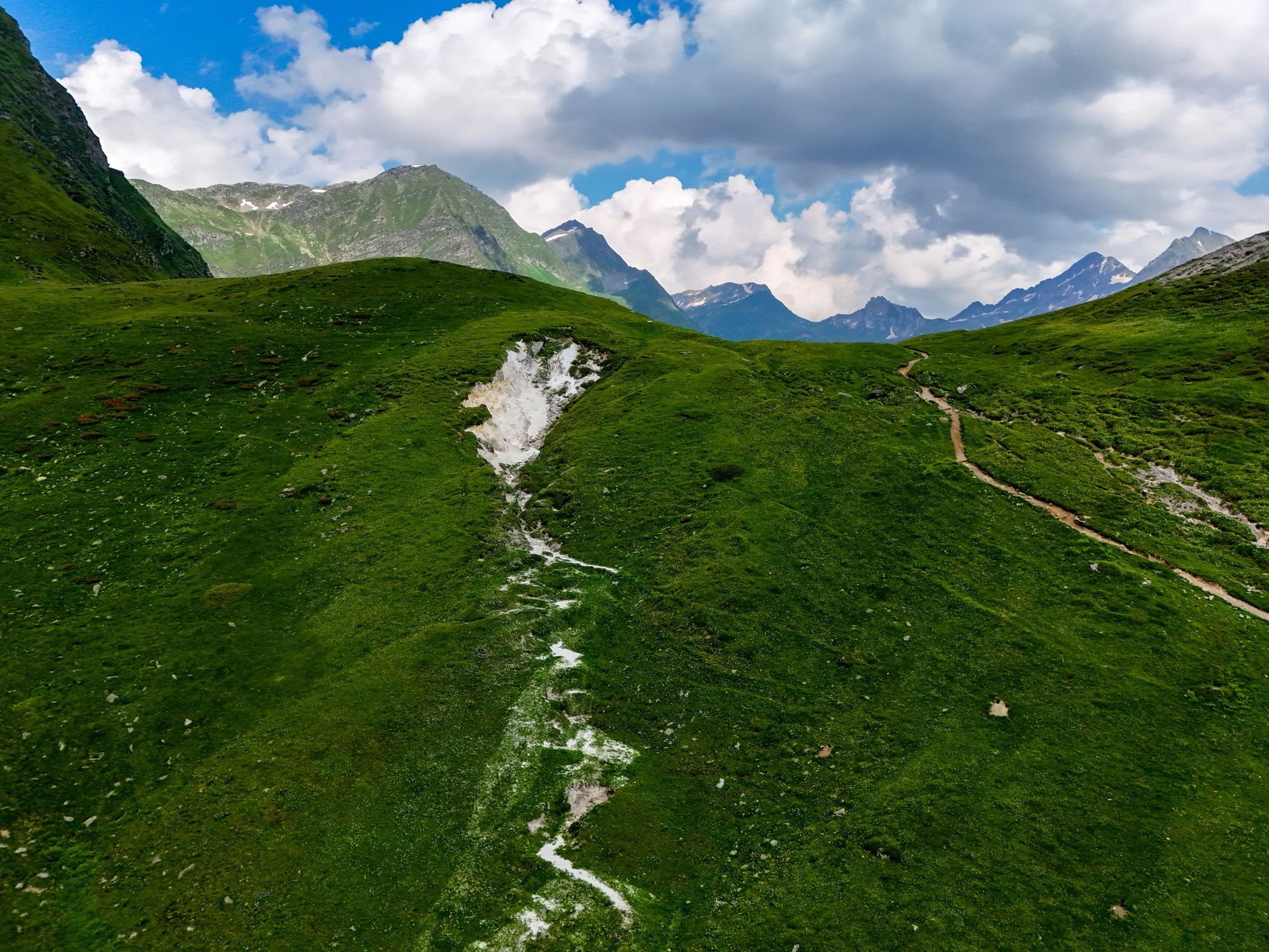 Green alpine landscape with mountain path